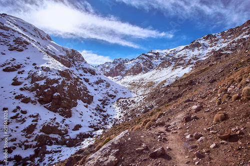Touristic path up to snowy High Atlas mountains Africa Morocco on sunny day