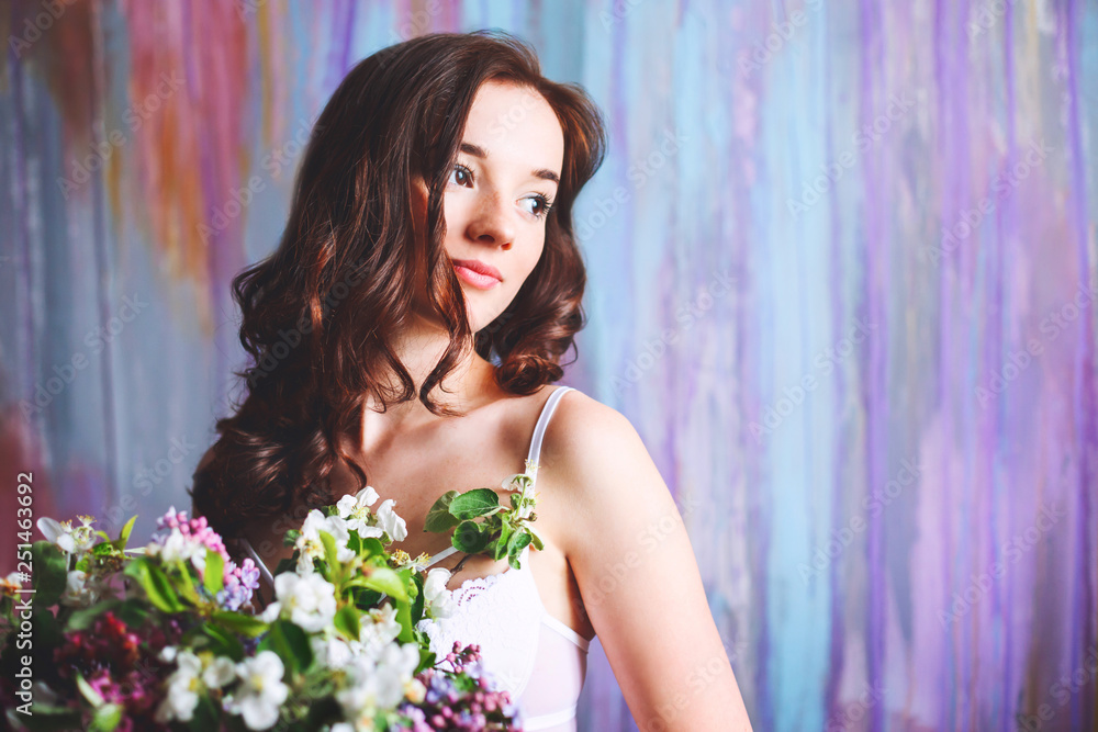 Beautiful young bride with a bouquet of flowers on a multicolored background