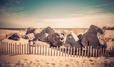 Picket fence, boulders and beach at Ocean Grove on a sunny winter day retro split tone