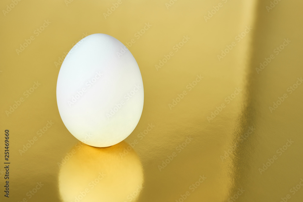 White egg with golden background. Easter concept. Copy space. White egg with golden background. Easter concept. Copy space.