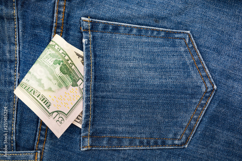 Paper banknotes 50 us dollars in the back pocket of blue jeans. Denim backgrounds. 