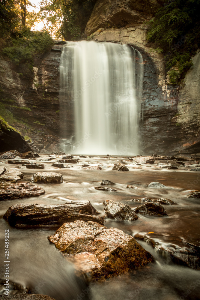 Obraz premium Smooth waterfall in woods with rocks