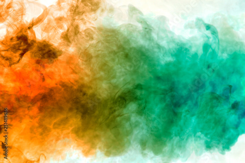 Colorful steam exhaled from the vape with a smooth transition of color molecules from yellow to blue on a white background like a collision of two jets of smoke. © Aleksandr Kondratov