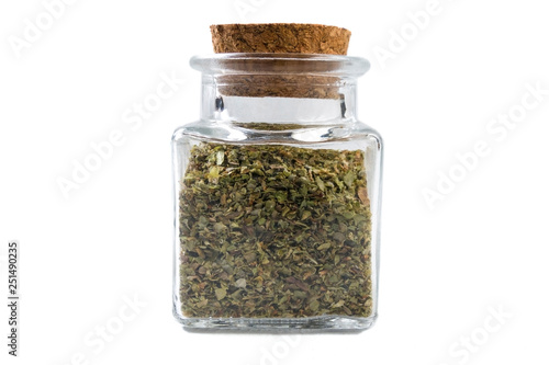 marjoram herb in a glass jar isolated on white background