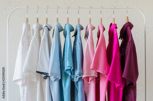 Man's polo shirts hanging in row in rack