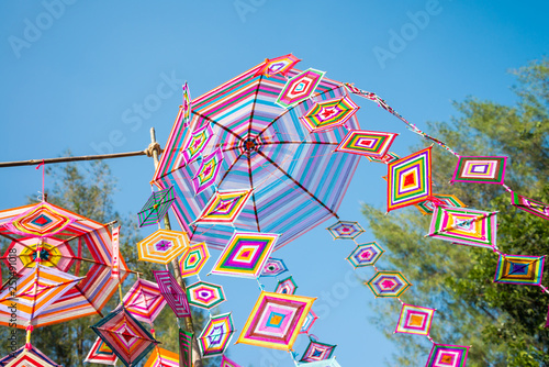 Colorful traditional bunting decoration in outdoor summer festival with blue sky background in city park. Summer holiday festival and celebration concept