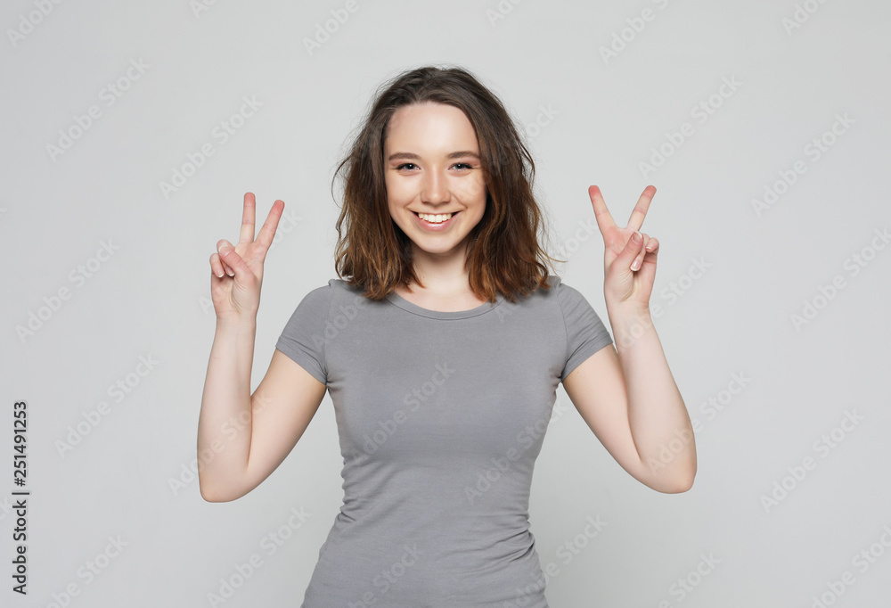 happy girl looking at camera with smile and showing peace sign with fingers happy girl looking at camera with smile and showing peace sign with fingers