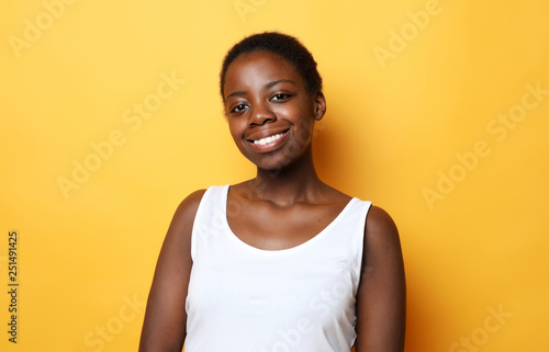  Beautiful happy young african woman  isolated over yellow  background  © Raisa Kanareva