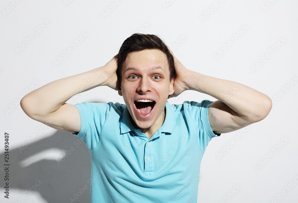 young man celebrating victory over white background young man celebrating victory over white background