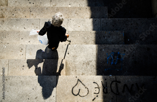Senior woman walking on the streets with a cane