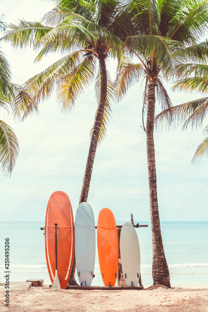 Surfboard and palm tree on beach background. - obrazy, fototapety, plakaty 