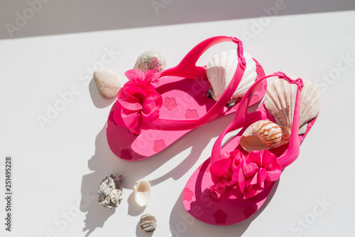 Fashionable sandals, seashells on white background, top view, flat lay.summer pink Shoes for kids, Children's slippers, beach fashion for baby, bright Sandals shoes,holiday concept