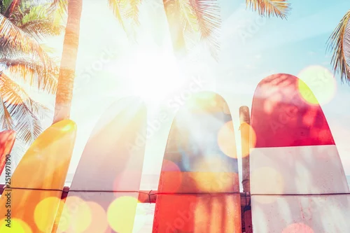 Obraz Deska surfingowa i palmy na tle plaży.