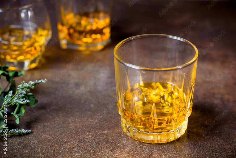 glasses of whiskey with ice cubes  on  bar.