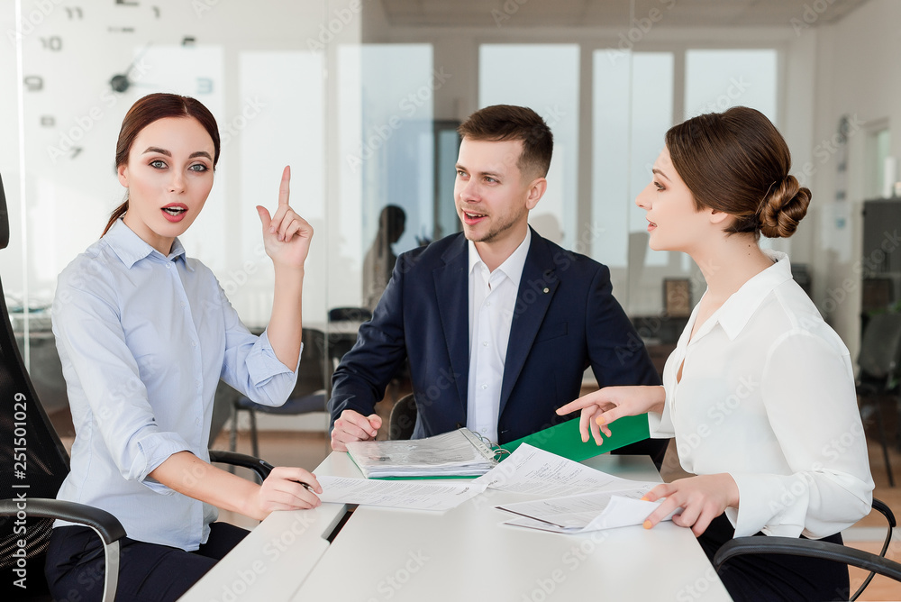 Successful young employees working together excited about new idea they have. Business concept of co-workers in the office space. Successful young employees working together excited about new idea they have. Business concept of co-workers in the office space.