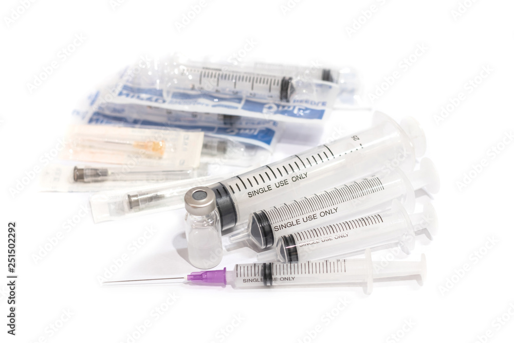 Vials with medication and injection needle isolated on white background. Multiple syringes. Syringes that stack together. Vials with medication and injection needle isolated on white background. Multiple syringes. Syringes that stack together.