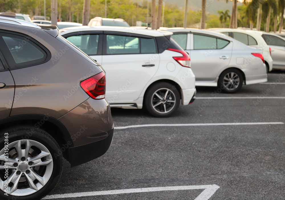 Closeup of back or rear side of brown car and other cars parking in parking area with natural background in twilight evening. 