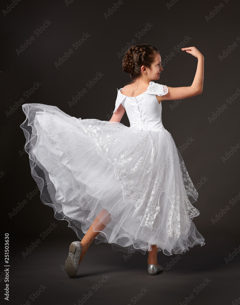 little girl is dancing in a white ball gown, dark background
