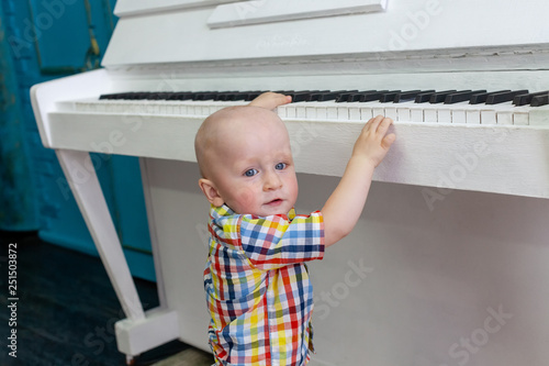 a little boy plays the piano
