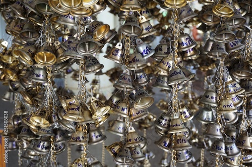 close up hanging small gold bells for luck in Wat Pongarkad , Chachoengsao , Thailand