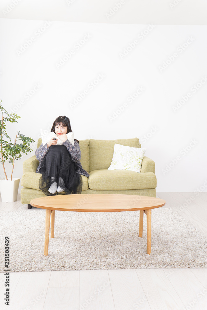 家でテレビを見る若い女性 家でテレビを見る若い女性