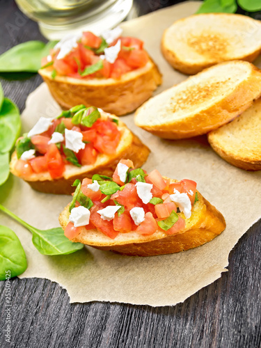 Bruschetta with tomato and cheese on wooden board