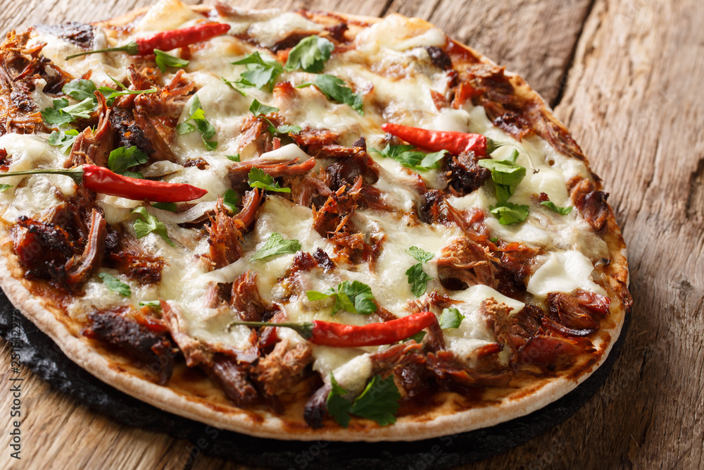 Homemade pizza with pulled pork, cheese, pepper and barbecue sauce close-up. horizontal, rustic style