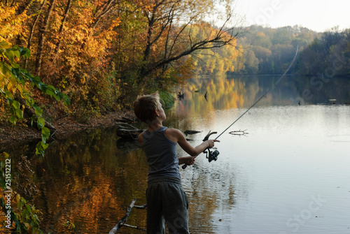 Young boy fishing in a forest lake © Ruslan