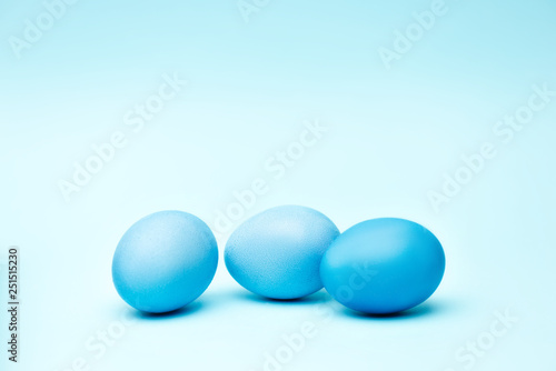 Painted easter eggs on blue background, monochrome view