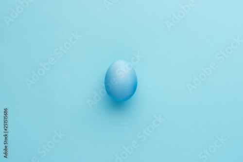 Painted blue egg on blue background, monochrome view