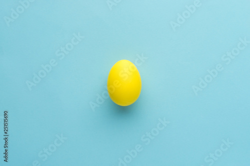Painted yellow egg on blue background