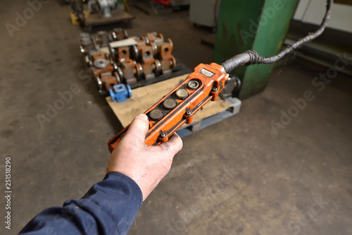 Wallpaper Mural Male hand holding an old and very dirty remote control panel with buttons for an electric winch at the factory Torontodigital.ca