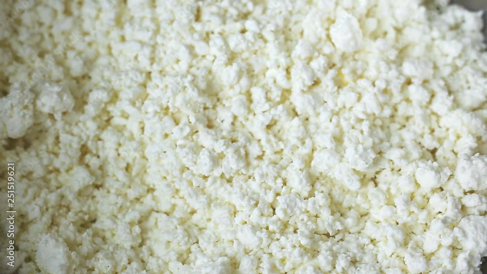 low-fat, useful from cow's milk, white crumbly curd is poured from above into an iron bowl. cooking cottage cheese low-fat, useful from cow's milk, white crumbly curd is poured from above into an iron bowl. cooking cottage cheese
