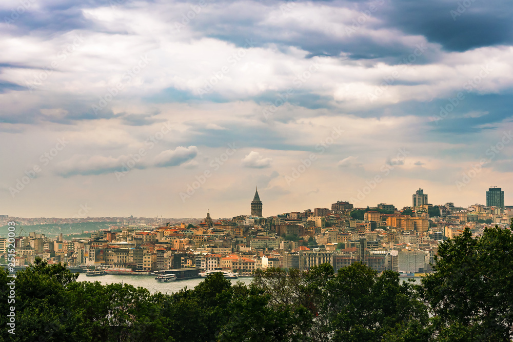 Cityscape of Istanbul with Galata tower under dramatic cloudy sky, Turkey