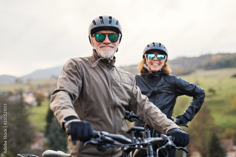 Active senior couple with electrobikes standing outdoors on a road in  nature. Stock 写真 | Adobe Stock