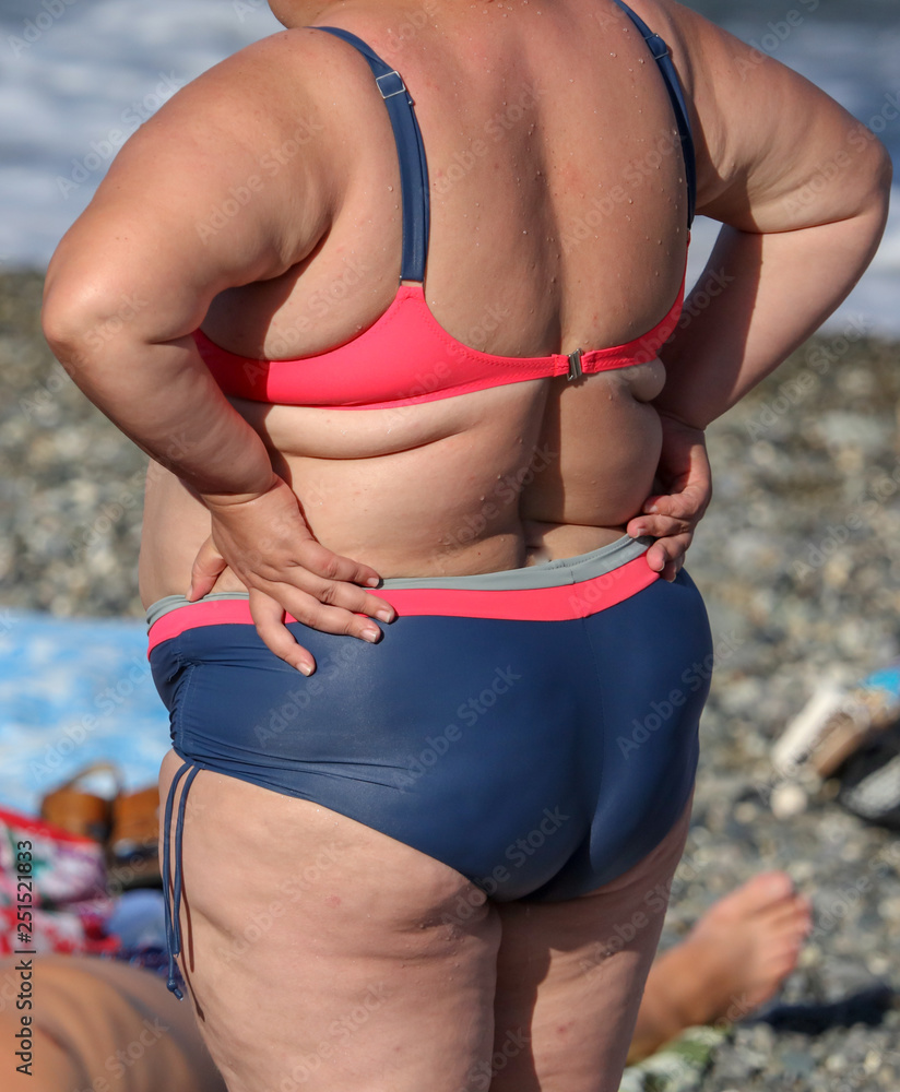 Fat woman in swimsuit on the sea beach Stock 写真 | Adobe Stock