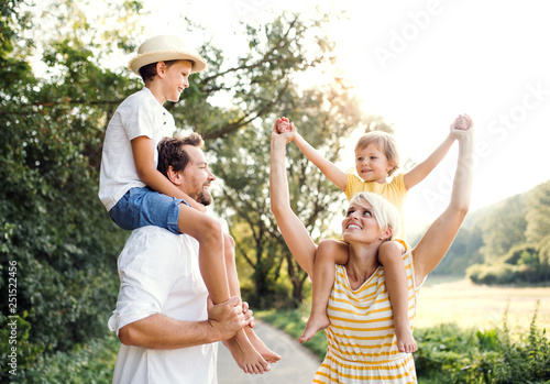 Young family with small children in sunny summer nature.