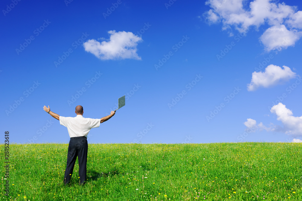 Businessman standing on green field Businessman standing on green field
