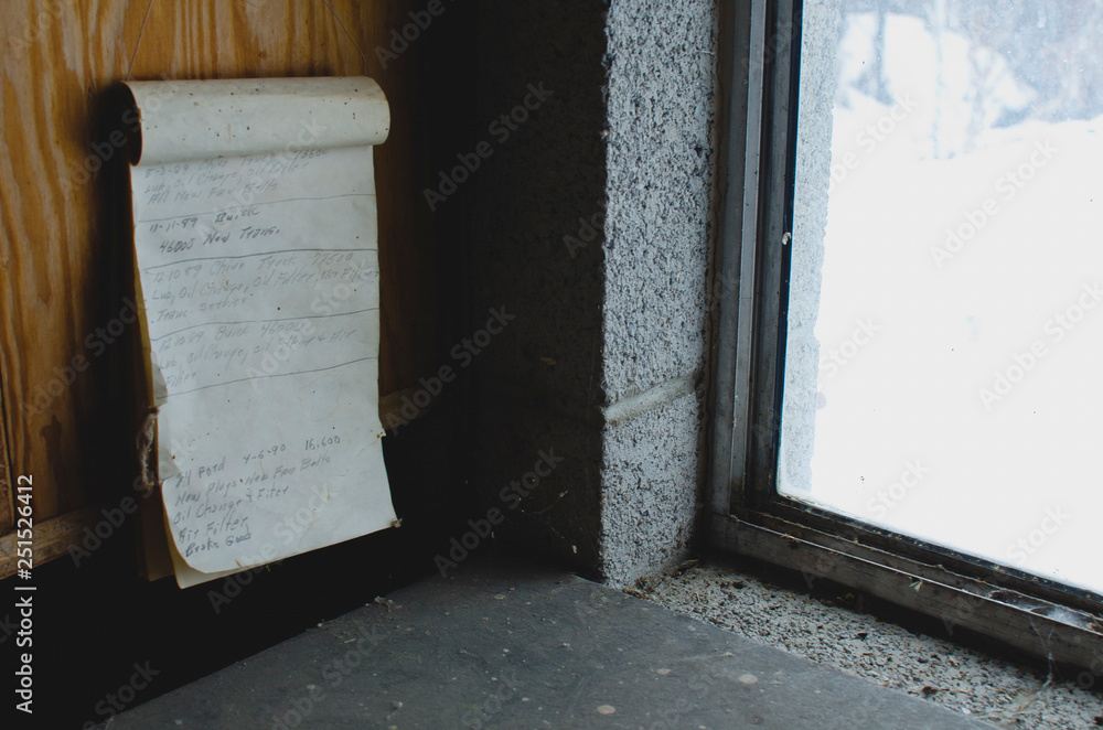 A old paper to do list on the old shelf in the garage work shop next to the cold window. A old paper to do list on the old shelf in the garage work shop next to the cold window.