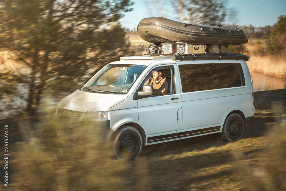 Transporter mit Schlauchboot auf dem Dach fährt durch Natur Stock-Foto |  Adobe Stock