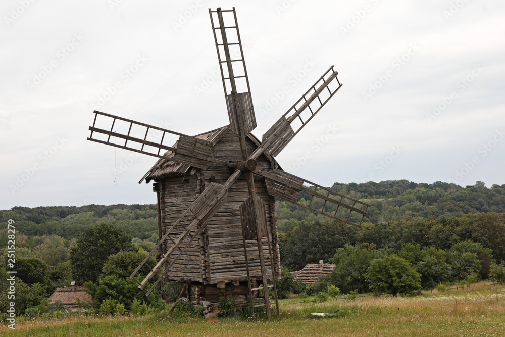 Wooden old windmill on field in summer in Ukraine Pirogovo Wooden old windmill on field in summer in Ukraine Pirogovo