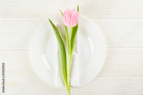 Table setting arrangement in minimal style with easter spring holiday attributes  fork  knife and napkin. Background  copy space  close up  flat lay  top view.