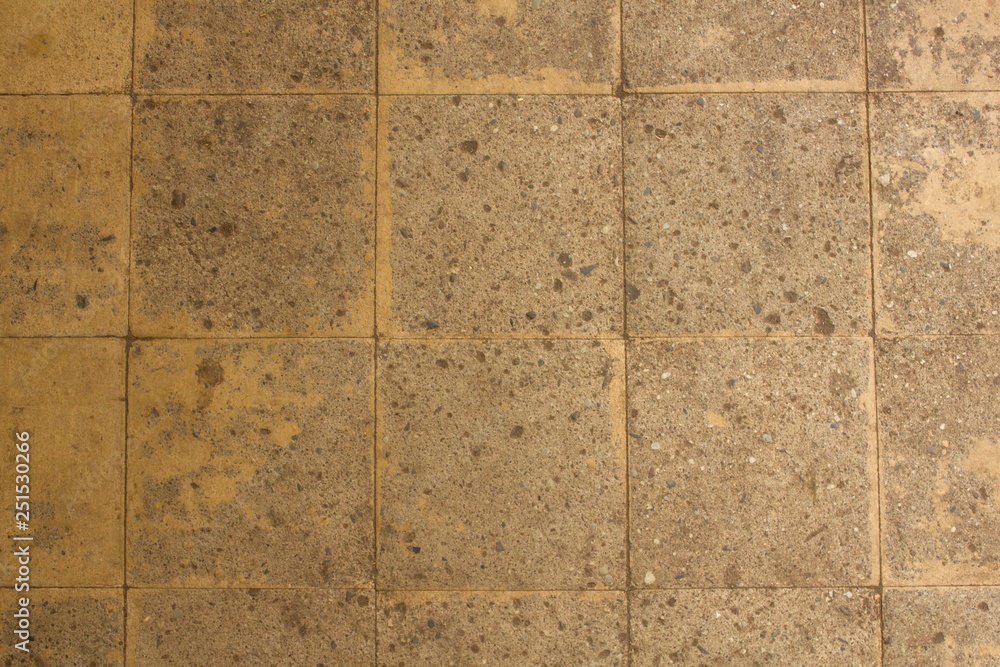 Fototapeta premium old yellow gray concrete tiled wall with damages. rough surface texture