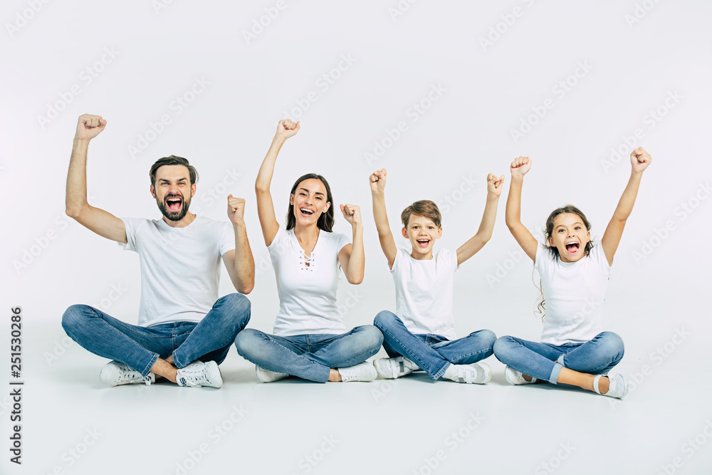 Happy and cheerful young beautiful family are smiling and posing while have a fun together over white background - obrazy, fototapety, plakaty 