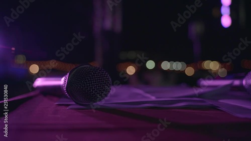 Wireless event microphone at night stage with color spotlight