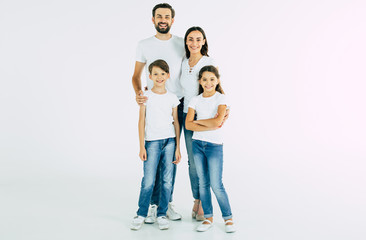 Happy and cheerful young beautiful family are smiling and posing while have a fun together over white background