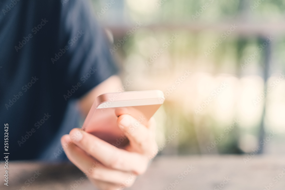 Woman hand using smart phone in cafe with green nature bokeh abstract background. Woman hand using smart phone in cafe with green nature bokeh abstract background.