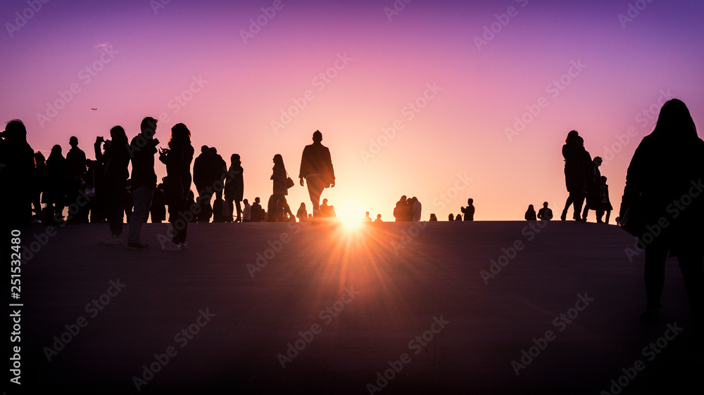 Group of people silhouette watching the sunset together