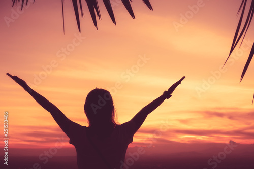 Copy space of woman rise hand up on top of mountain and sunset sky abstract background. © tonktiti