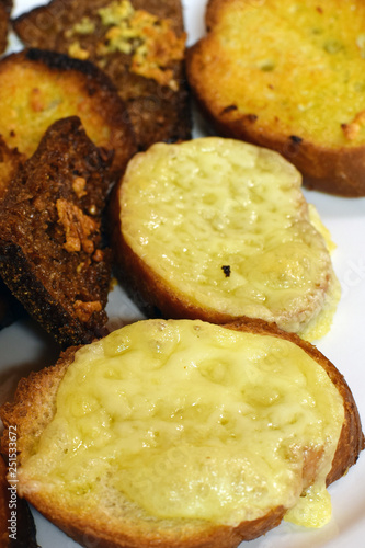 Fried bread slices with melted cheese. Vertical close up image.